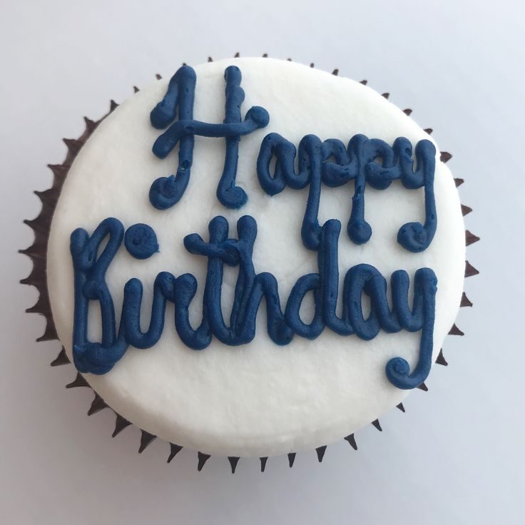 Cupcake with a white fondant topper and blue piped Happy Birthday lettering