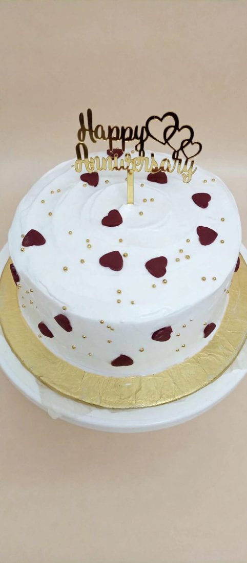 White-frosted cake with red accents and a personalized celebration message