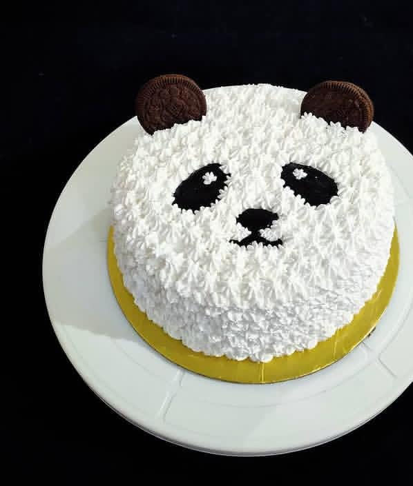 Round cake decorated as a panda face with textured white cream