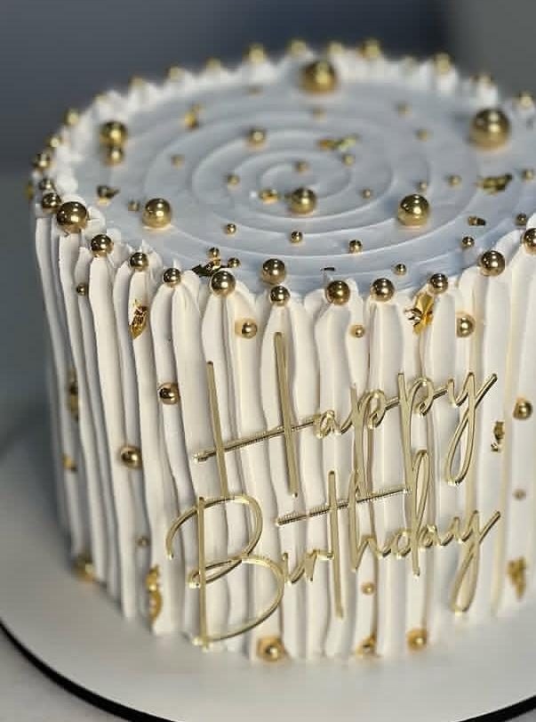 Elegant white cake with fine gold drip lines and gold accents