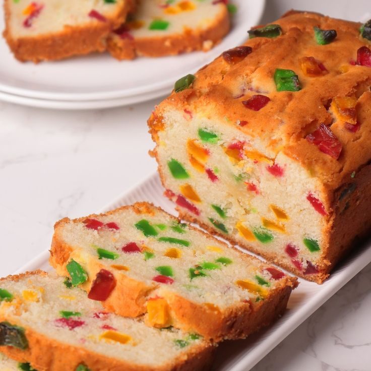 Sliced tutti frutti loaf cake studded with red, green and orange fruit pieces